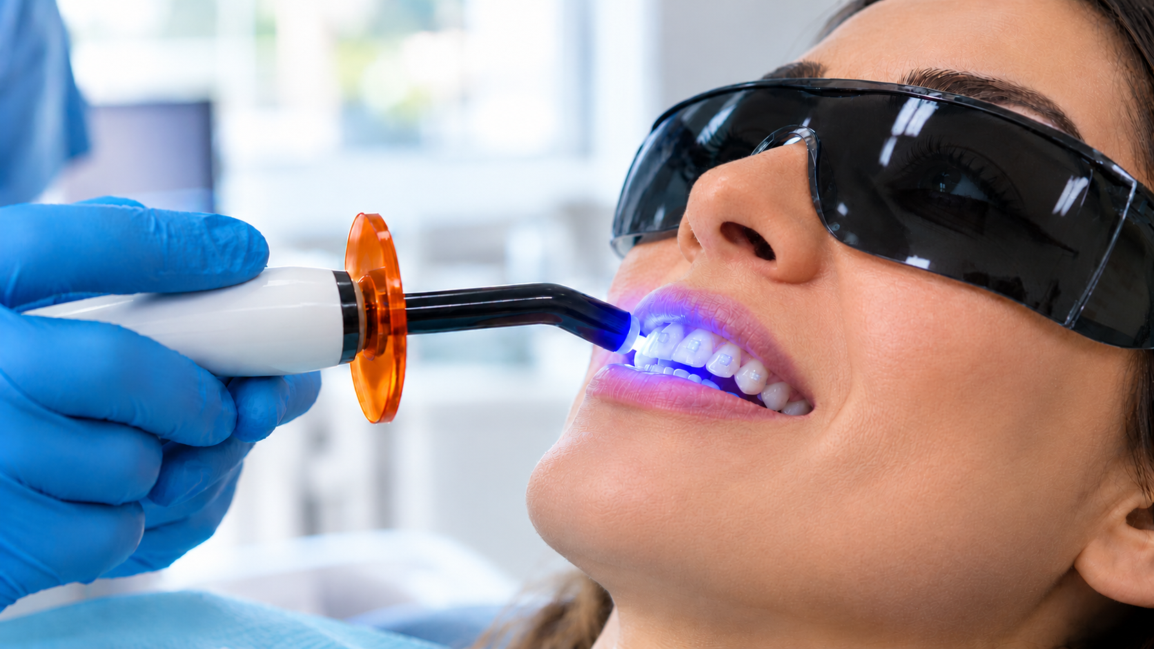How Invisalign Attachments Are Placed in Welland | Rose City Dental Centre Blue curing light hardening composite resin to place Invisalign attachments in Welland